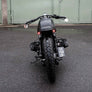 photo du derrière d'une moto toute noire bmw cafe racer